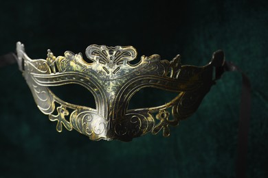 Photo of Theater arts. Venetian carnival mask against green fabric, closeup