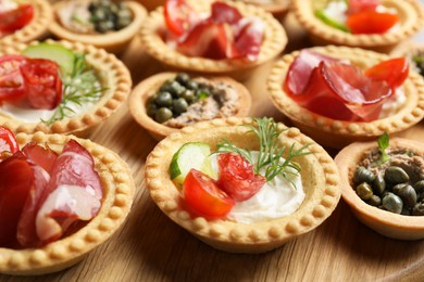 Delicious canapes with jamon and cream cheese on table, closeup