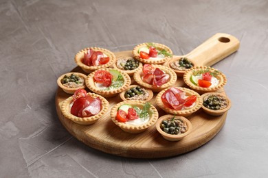 Delicious canapes with jamon, pate and dry smoked sausages on grey textured table