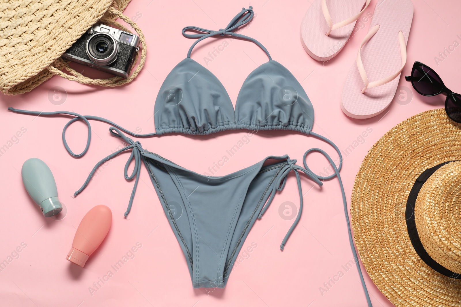 Photo of Flat lay composition with beautiful swimsuit on pink background