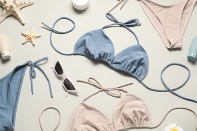 Photo of Flat lay composition with beautiful swimsuits on light grey background