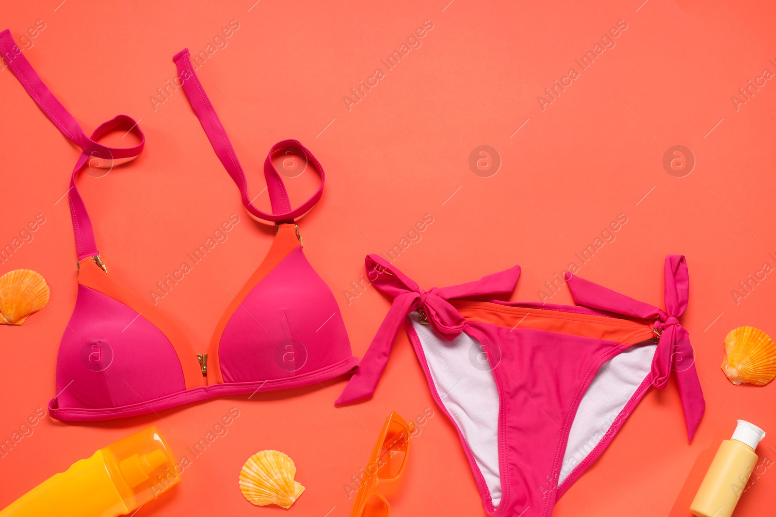 Photo of Flat lay composition with beautiful swimsuit on coral background. Space for text