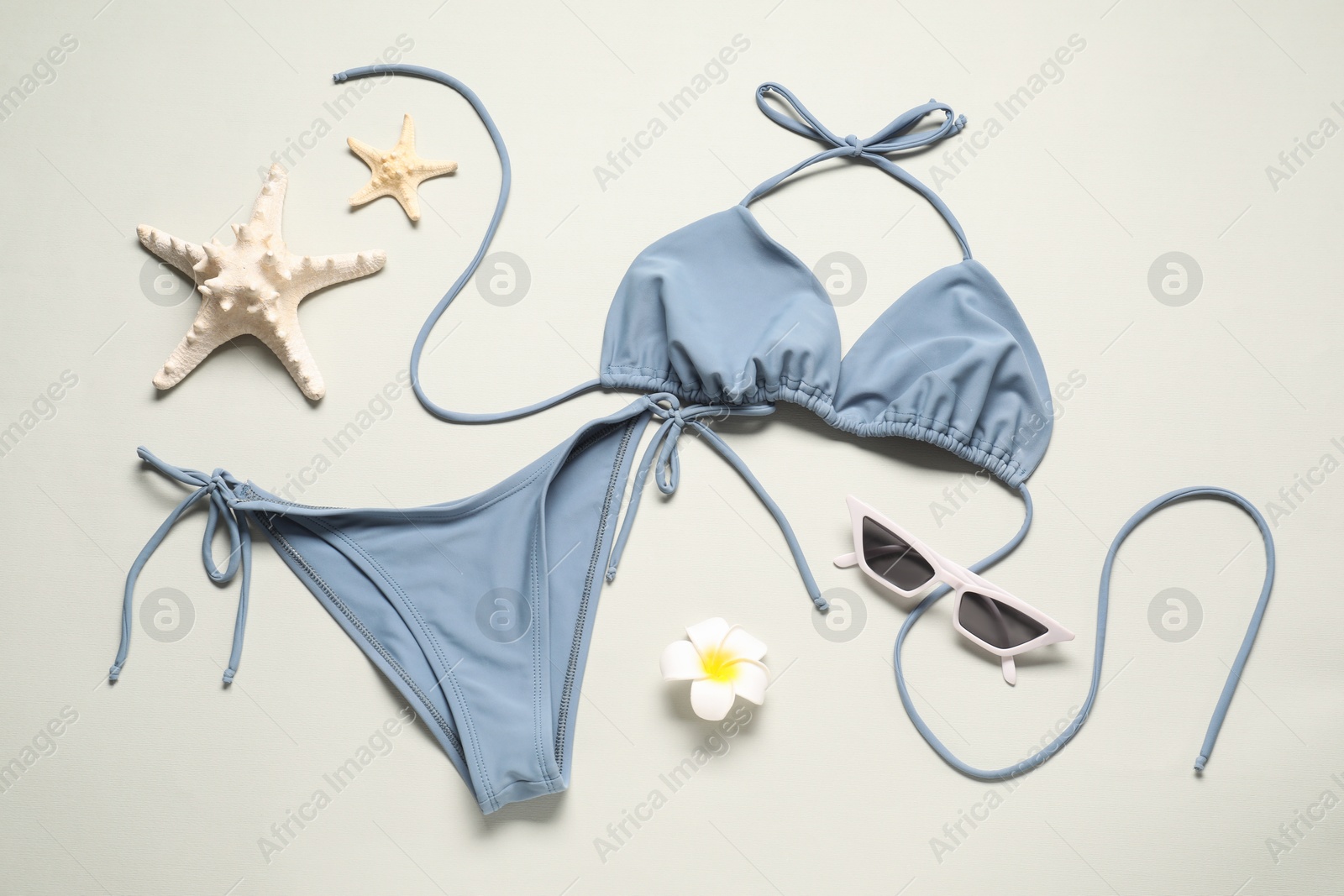 Photo of Flat lay composition with beautiful swimsuit on light grey background