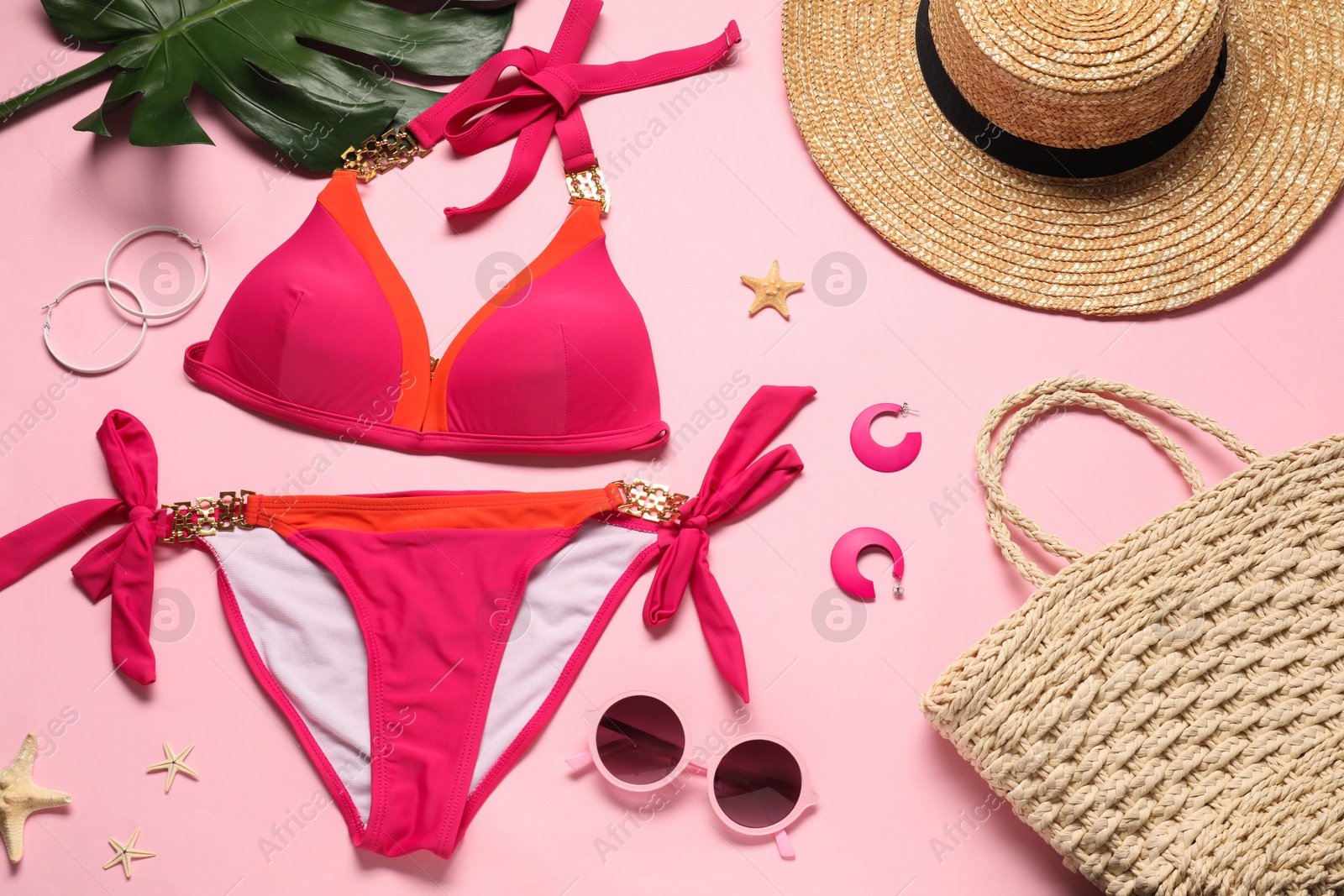 Photo of Flat lay composition with beautiful swimsuit, hat and bag on pink background