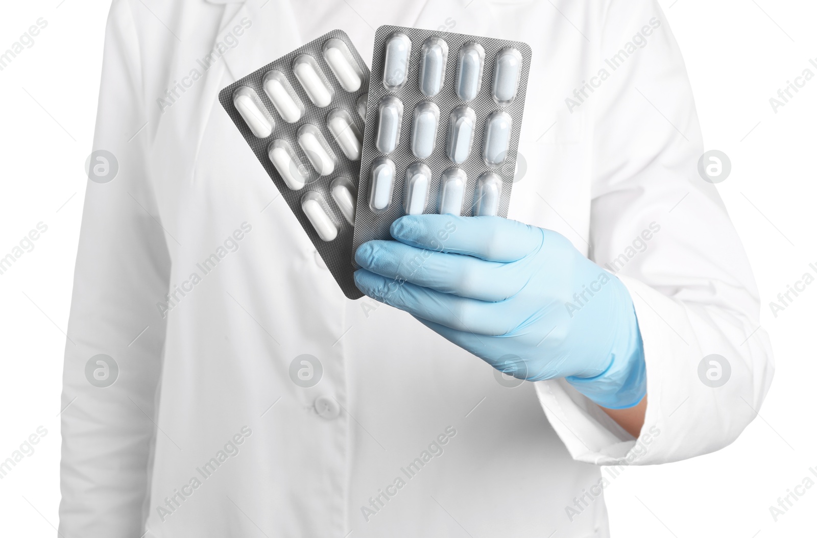 Photo of Doctor holding blisters with antibiotic pills on white background, closeup