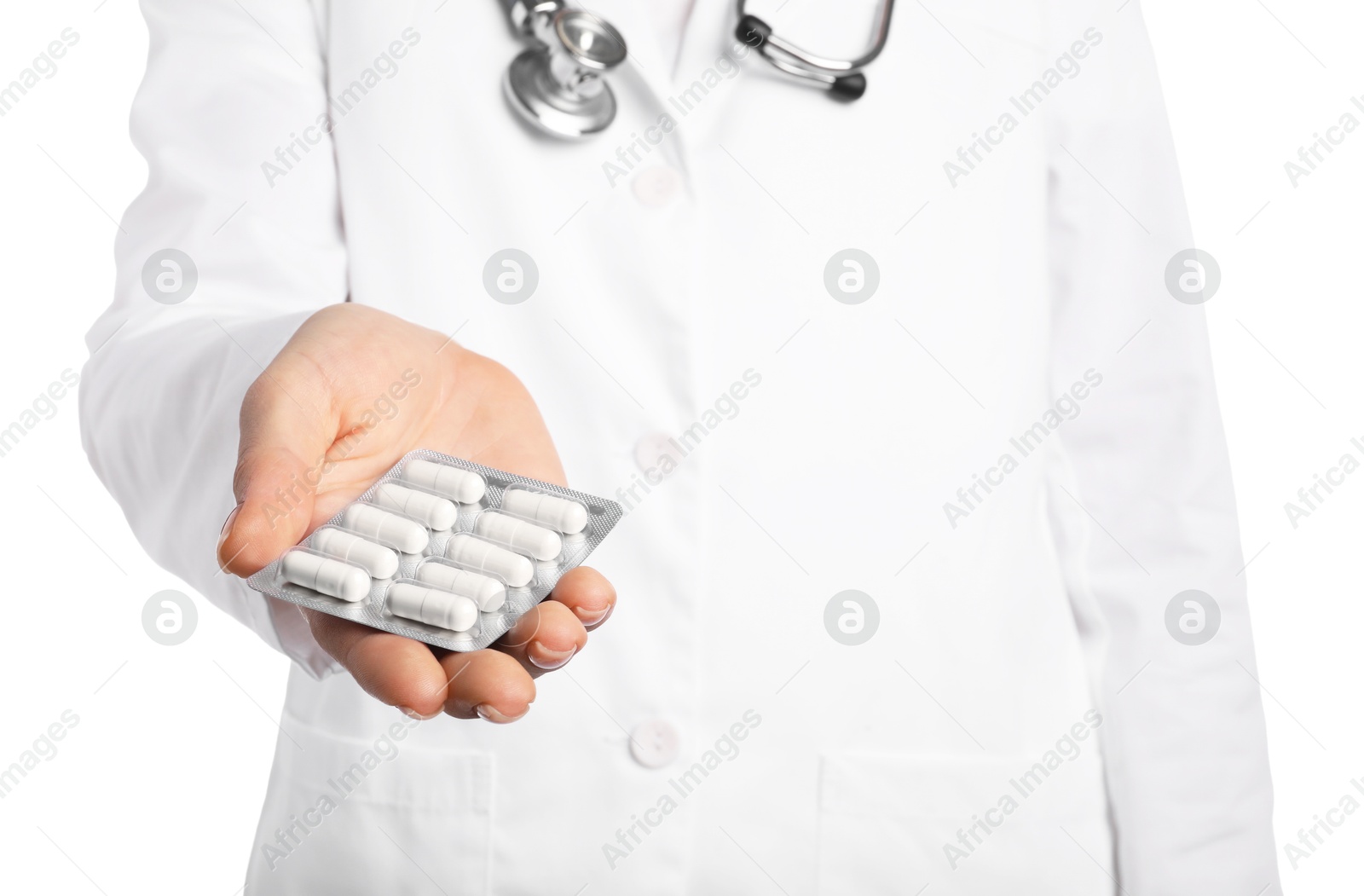 Photo of Doctor holding blister with antibiotic pills on white background, closeup