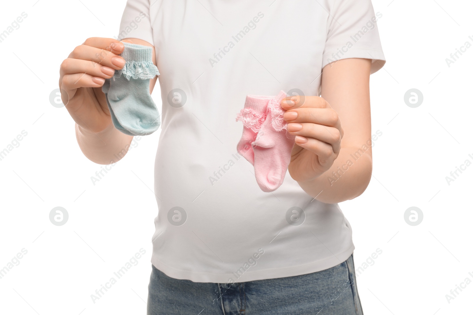 Photo of Expecting twins. Pregnant woman holding two pairs of socks on white background, closeup