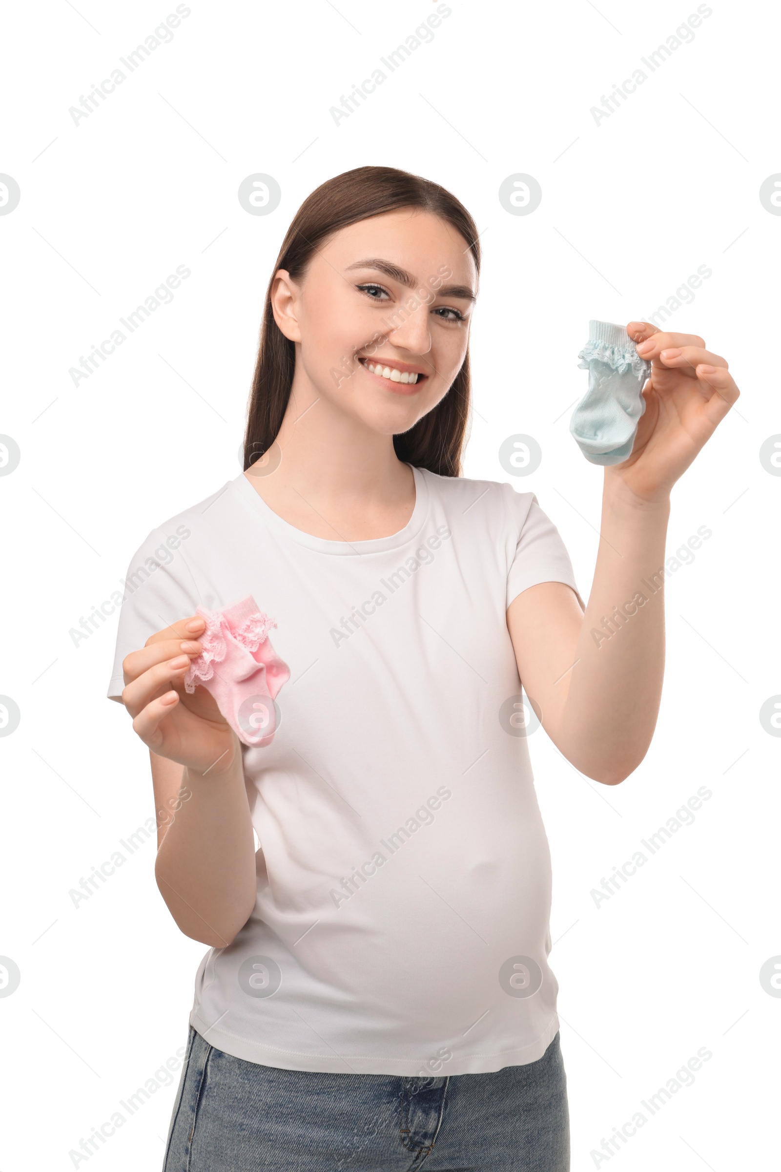 Photo of Expecting twins. Pregnant woman holding two pairs of socks on white background