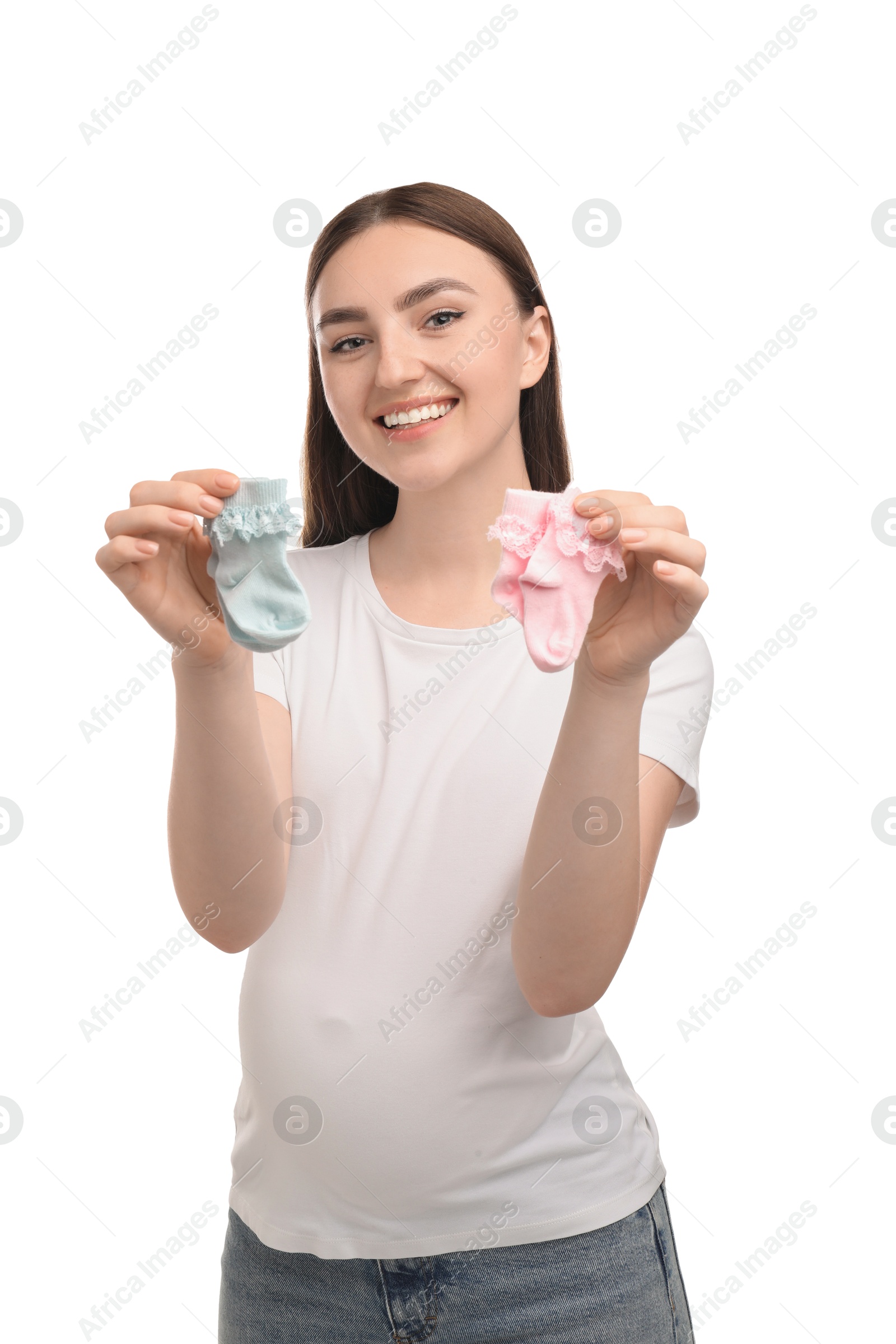 Photo of Expecting twins. Pregnant woman holding two pairs of socks on white background