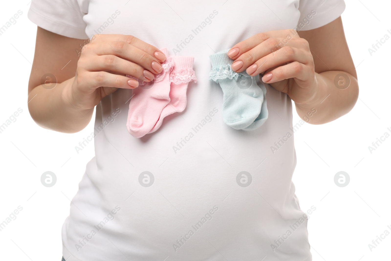 Photo of Expecting twins. Pregnant woman holding two pairs of socks on white background, closeup