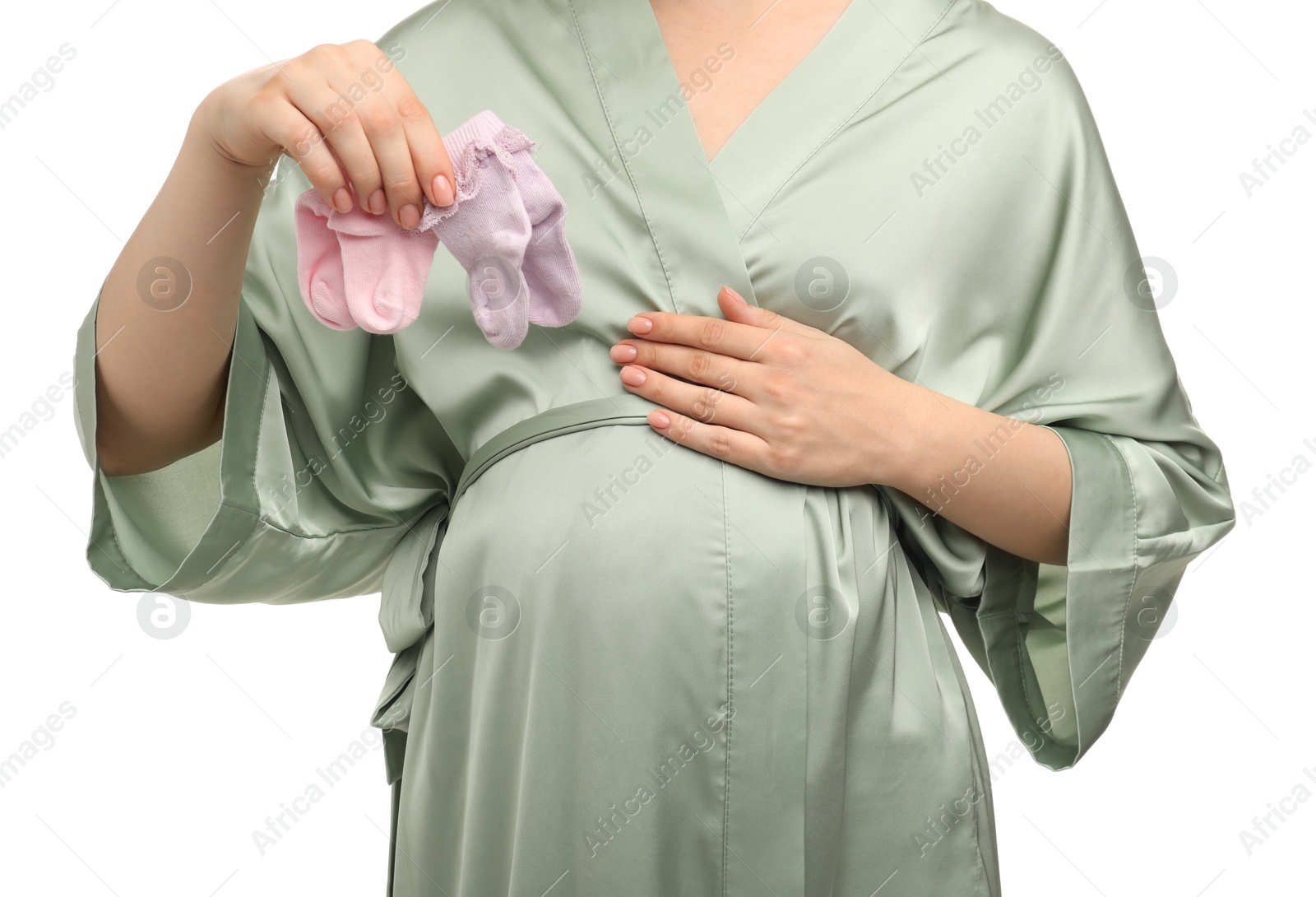 Photo of Expecting twins. Pregnant woman holding two pairs of socks on white background, closeup