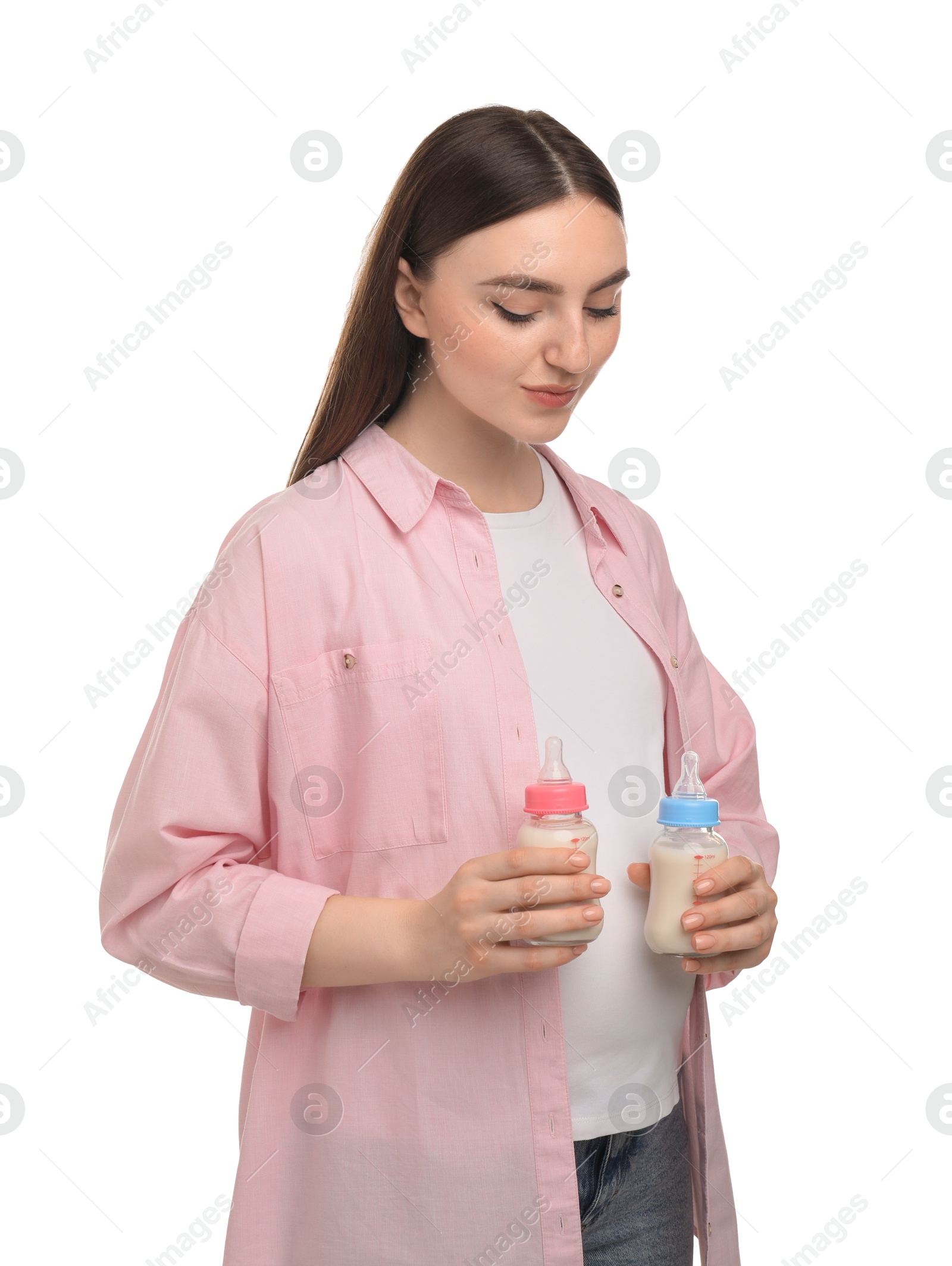 Photo of Expecting twins. Pregnant woman holding two bottles with milk on white background