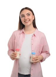 Photo of Expecting twins. Pregnant woman holding two bottles with milk on white background