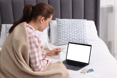 Sick woman having online consultation with doctor via laptop at home