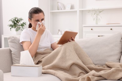 Sick woman having online consultation with doctor via tablet at home