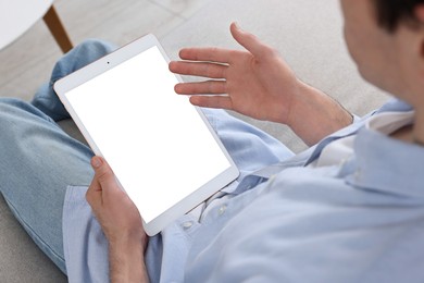 Photo of Sick man having online consultation with doctor via tablet at home, closeup