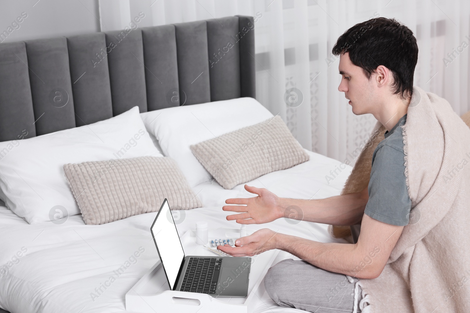 Photo of Sick man having online consultation with doctor via laptop at home