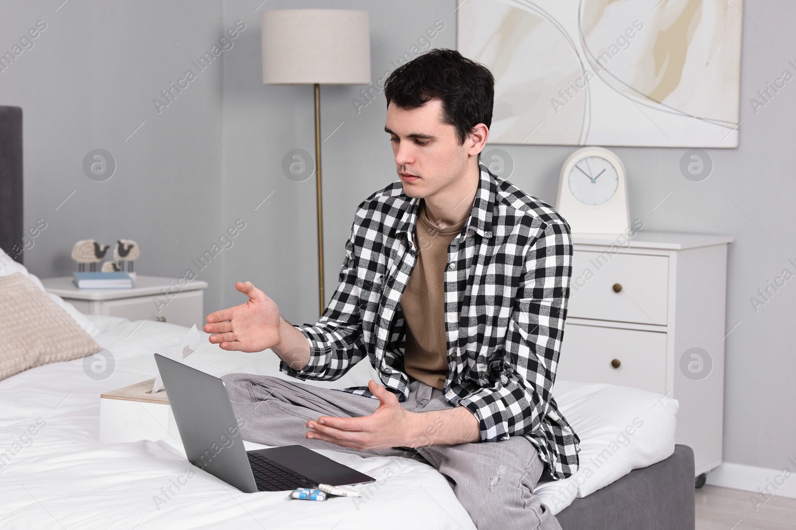 Photo of Sick man having online consultation with doctor via laptop at home