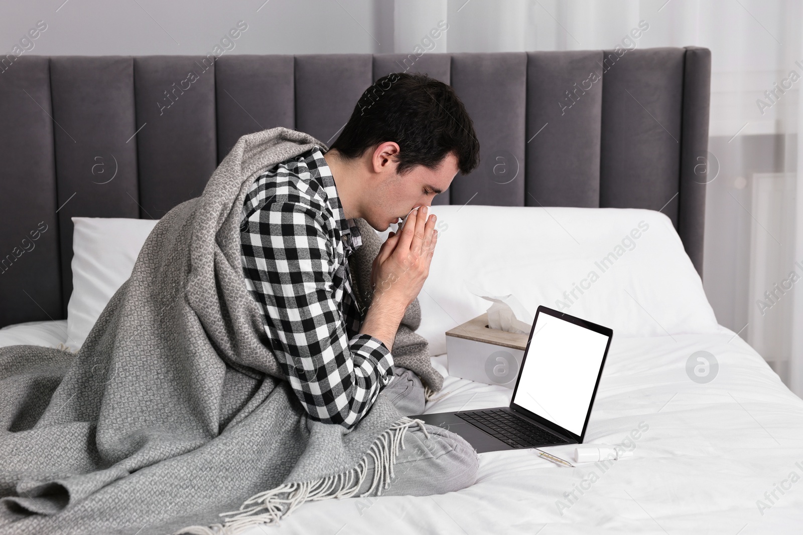 Photo of Sick man having online consultation with doctor via laptop at home