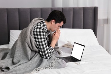 Photo of Sick man having online consultation with doctor via laptop at home