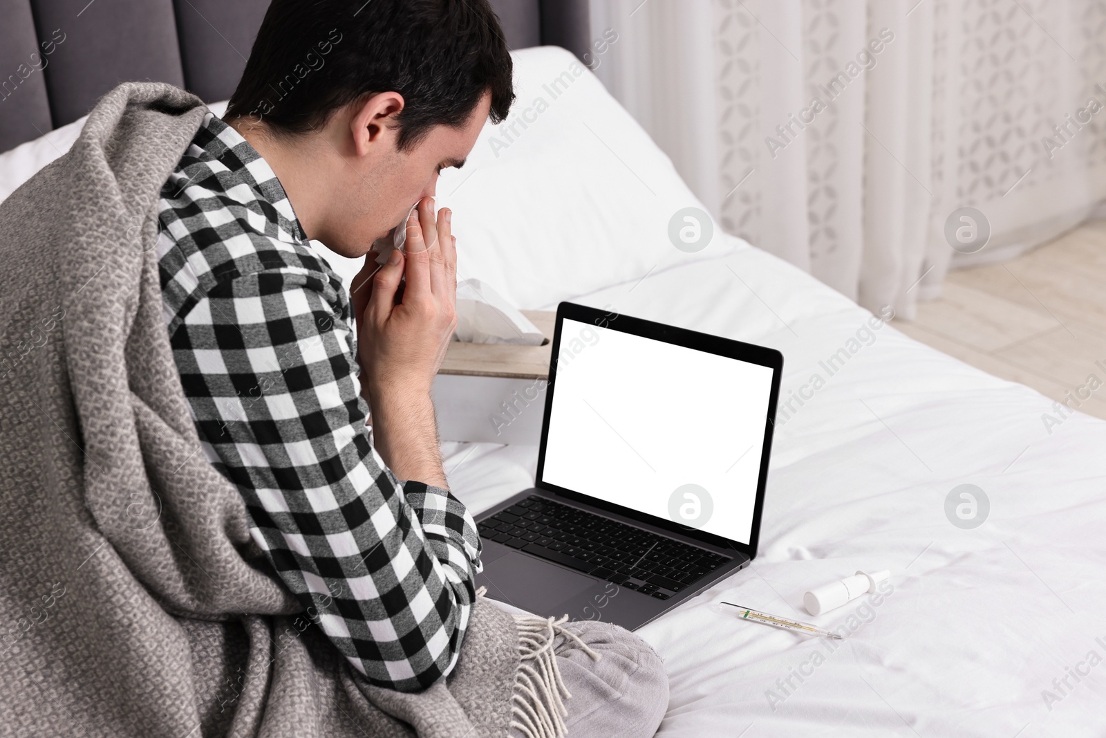 Photo of Sick man having online consultation with doctor via laptop at home