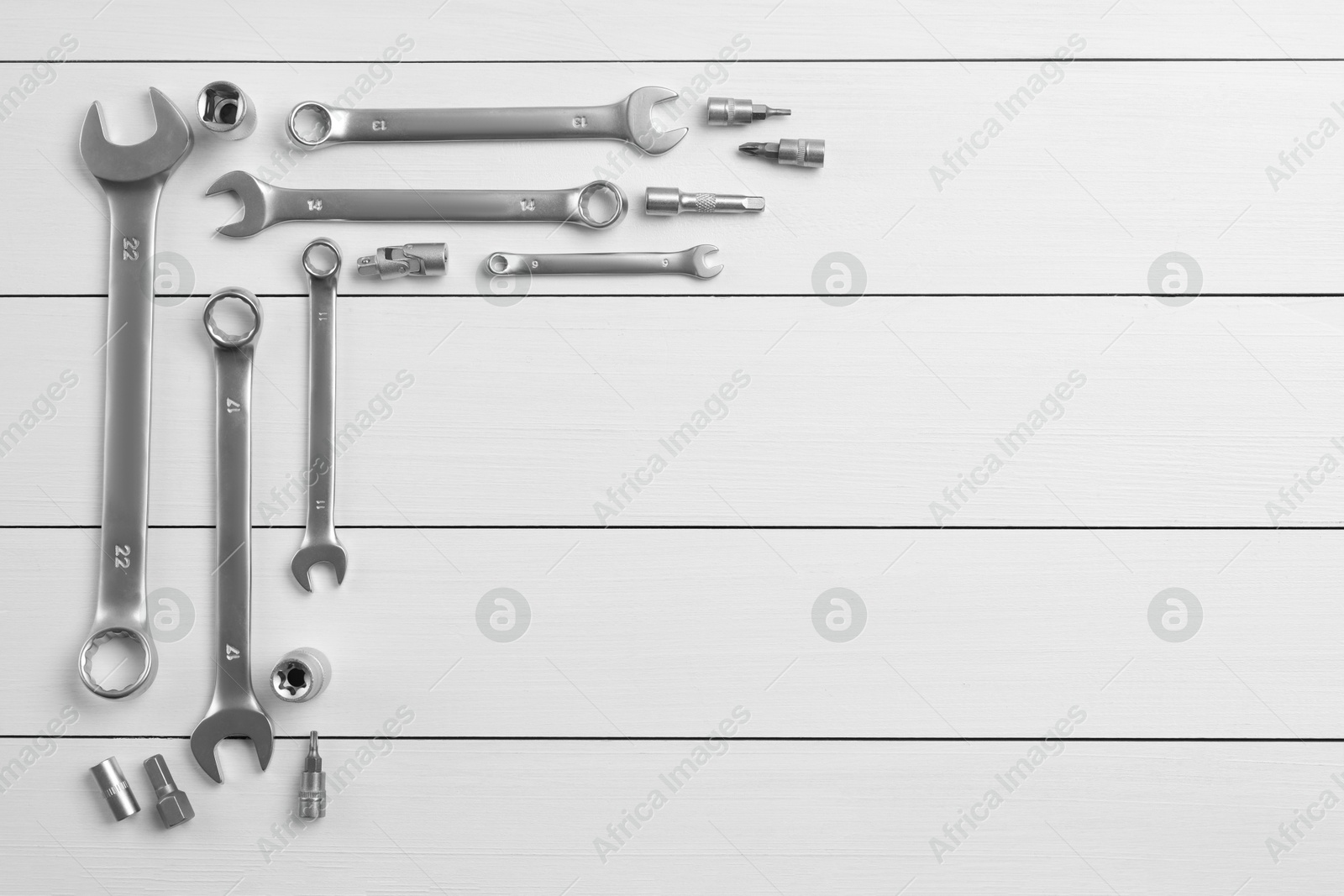 Photo of Auto mechanic's tools on white wooden table, flat lay. Space for text