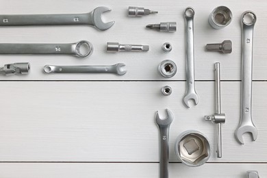 Auto mechanic's tools on white wooden table, flat lay. Space for text