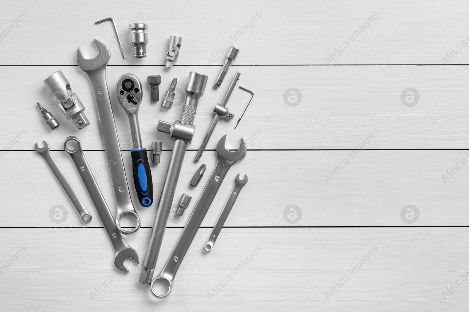 Photo of Auto mechanic's tools on white wooden table, flat lay. Space for text