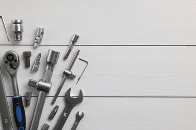 Auto mechanic's tools on white wooden table, flat lay. Space for text