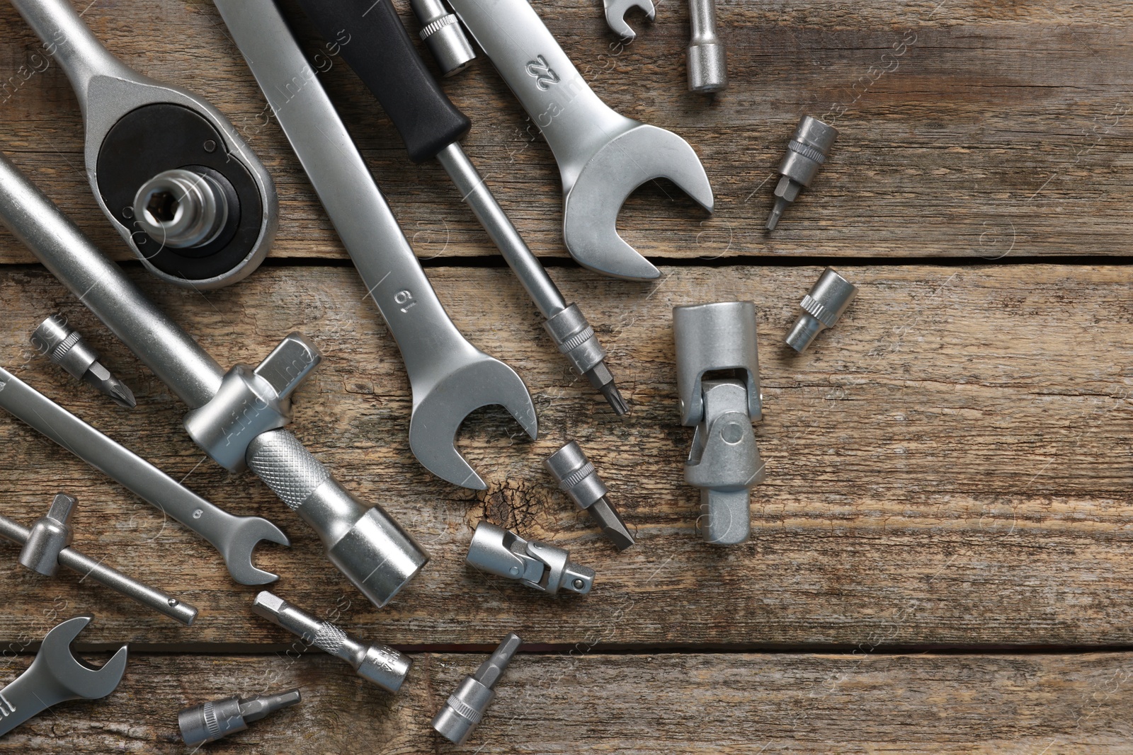 Photo of Different auto mechanic's tools on wooden table, flat lay. Space for text