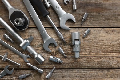 Photo of Different auto mechanic's tools on wooden table, flat lay. Space for text