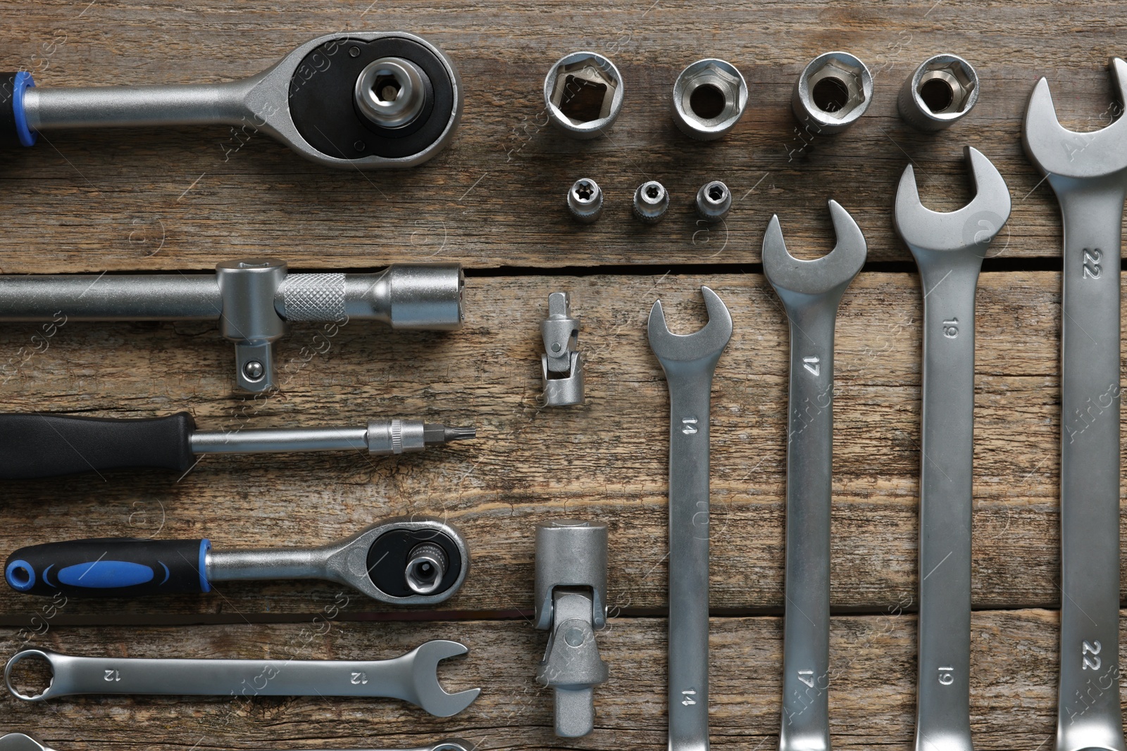 Photo of Different auto mechanic's tools on wooden table, flat lay