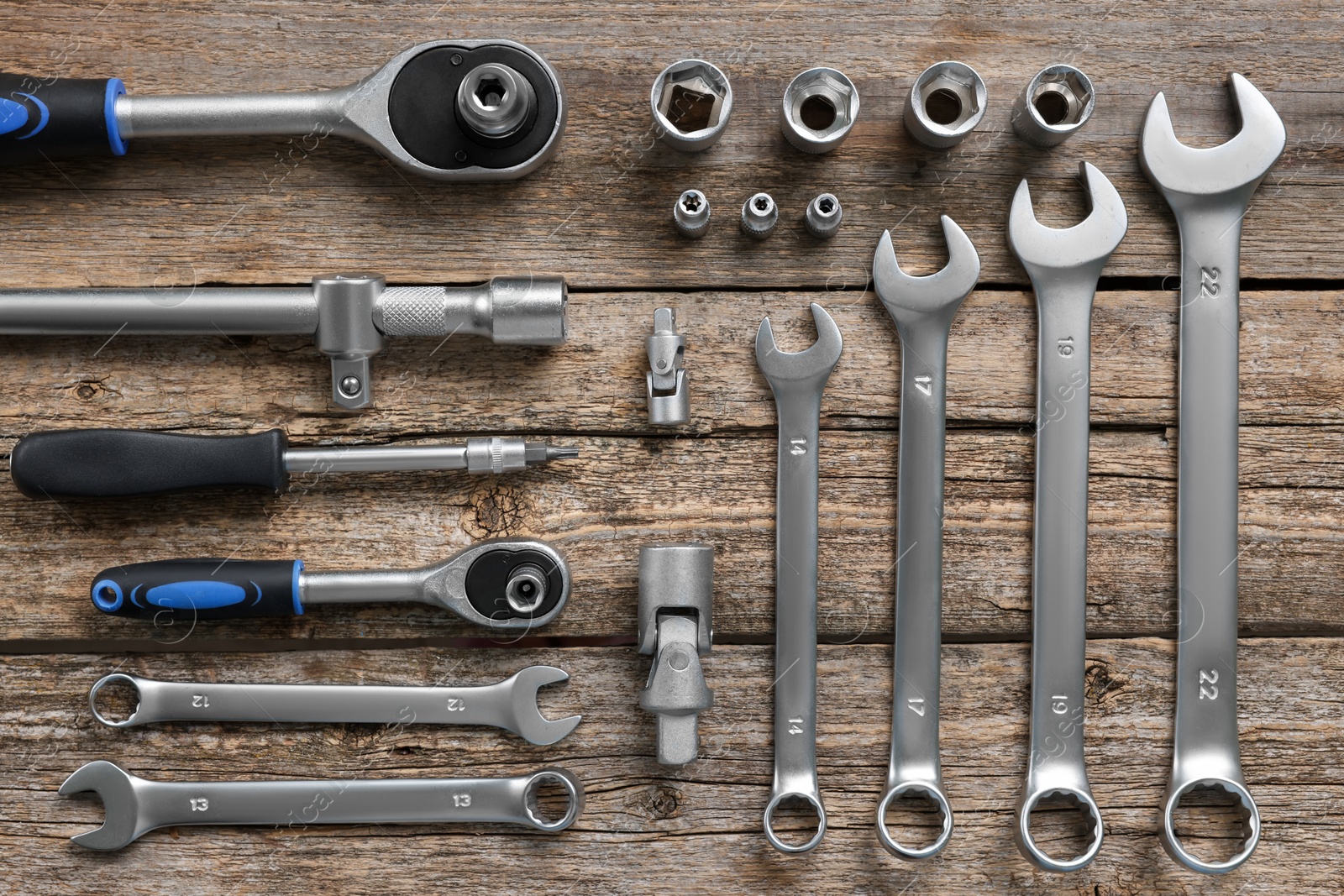 Photo of Different auto mechanic's tools on wooden table, flat lay