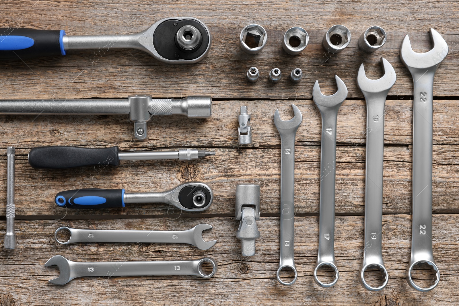 Photo of Different auto mechanic's tools on wooden table, flat lay