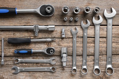 Different auto mechanic's tools on wooden table, flat lay