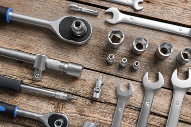 Photo of Different auto mechanic's tools on wooden table, flat lay