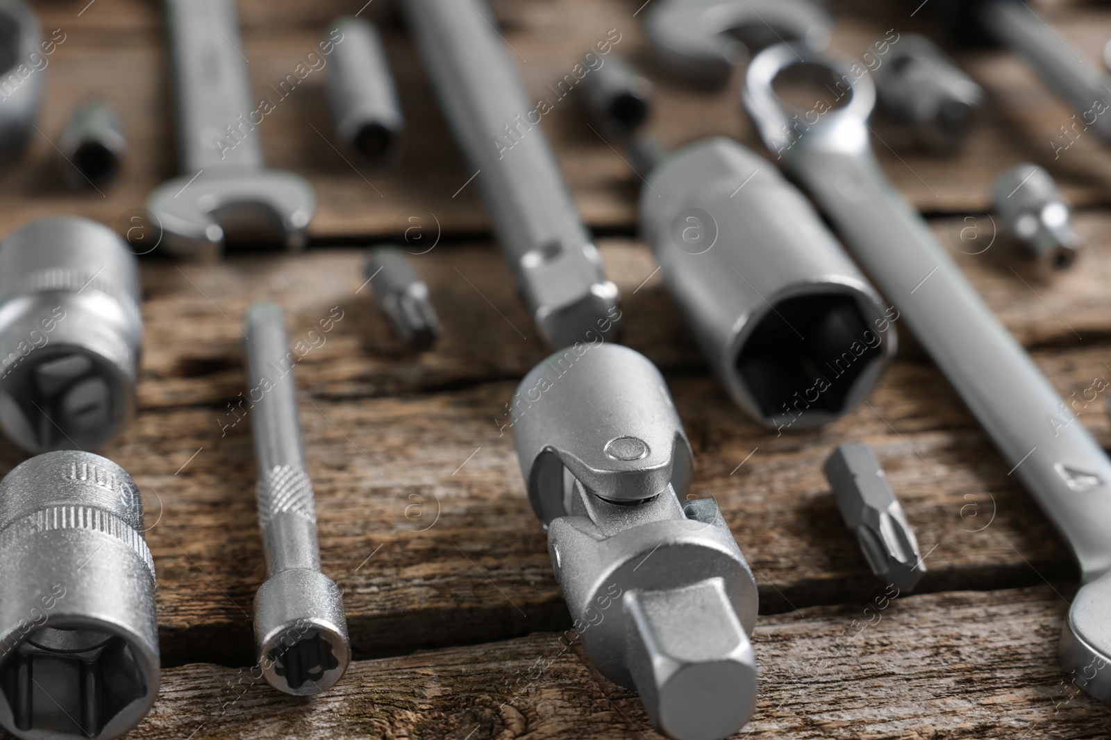 Photo of Different auto mechanic's tools on wooden table, closeup