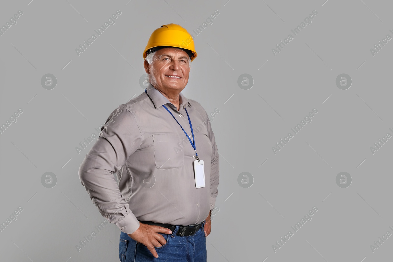 Photo of Engineer in hard hat on grey background, space for text