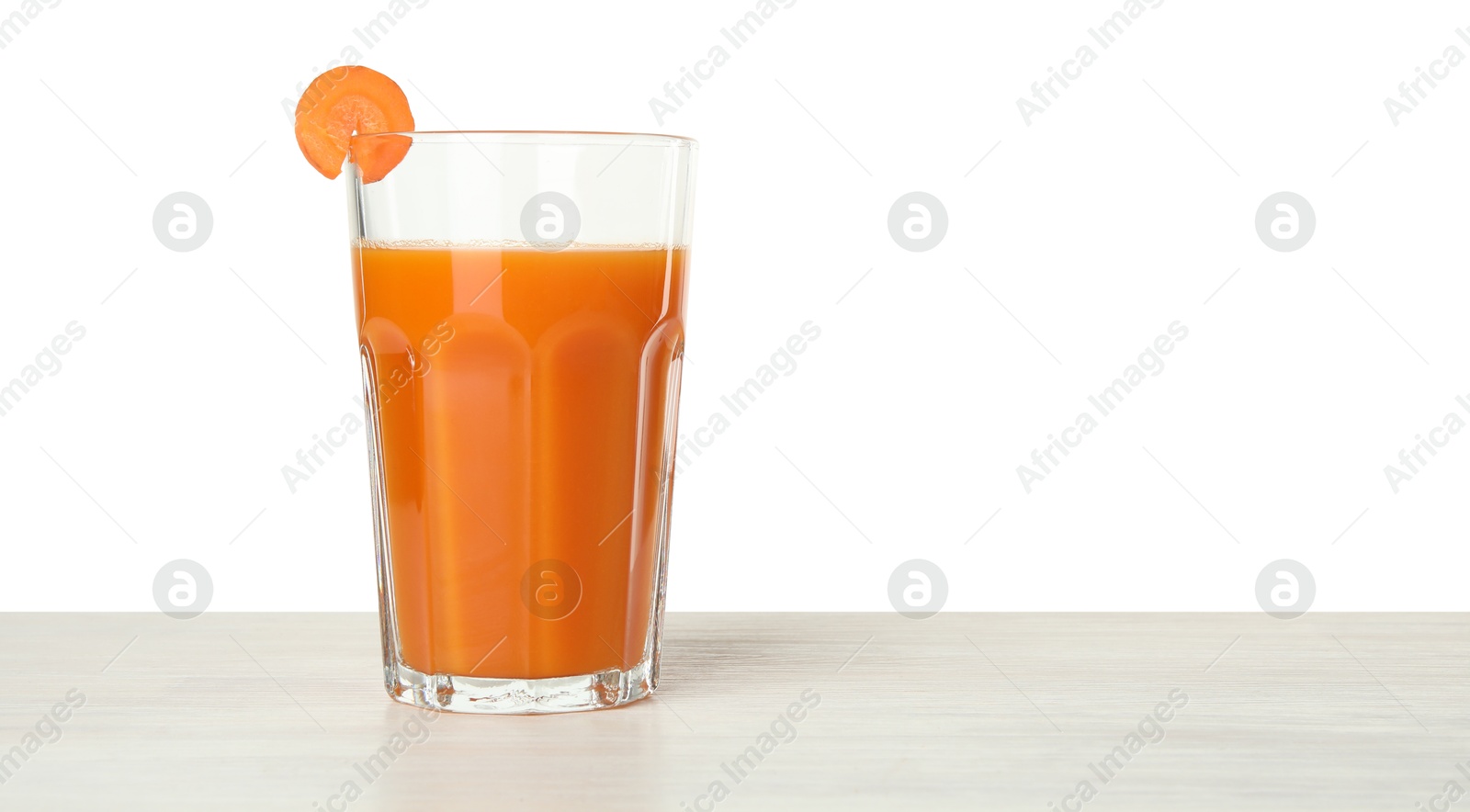 Photo of Fresh carrot juice in glass on wooden table against white background. Space for text