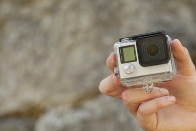 Man with modern action camera outdoors, closeup. Space for text