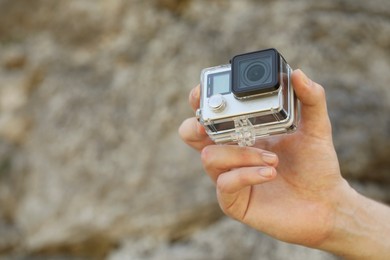 Man with modern action camera outdoors, closeup. Space for text