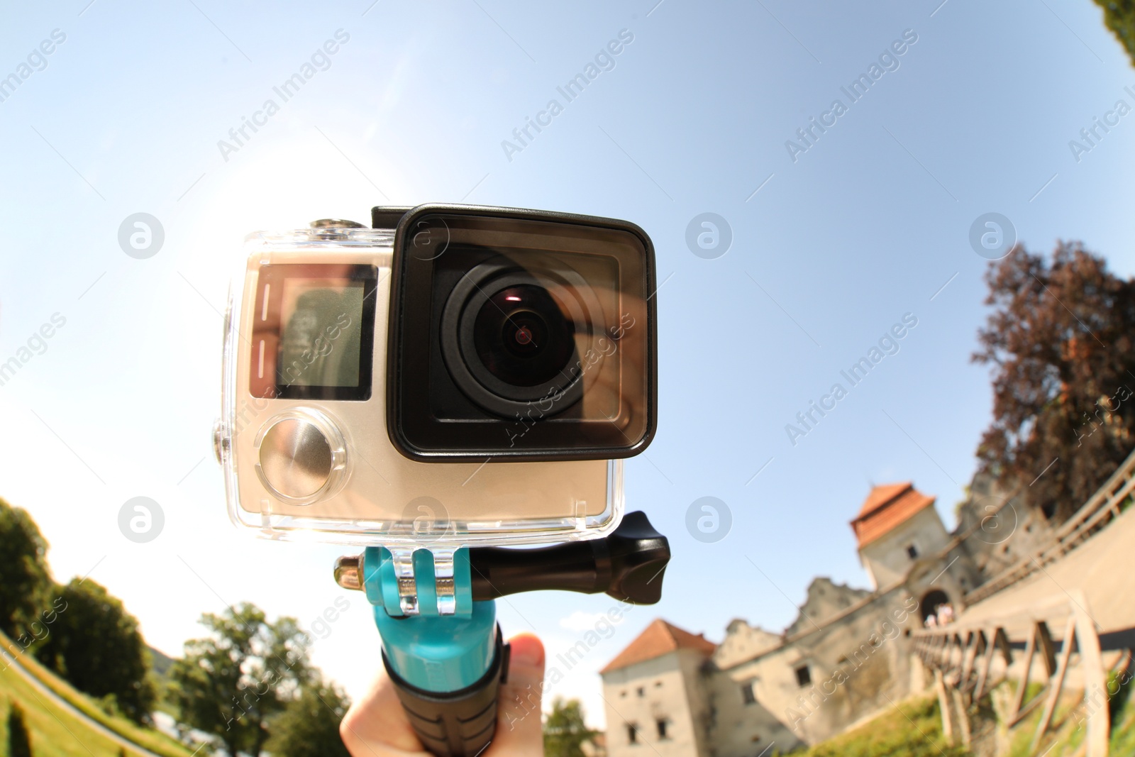 Photo of Man with modern action camera and monopod outdoors, closeup. Fisheye lens effect