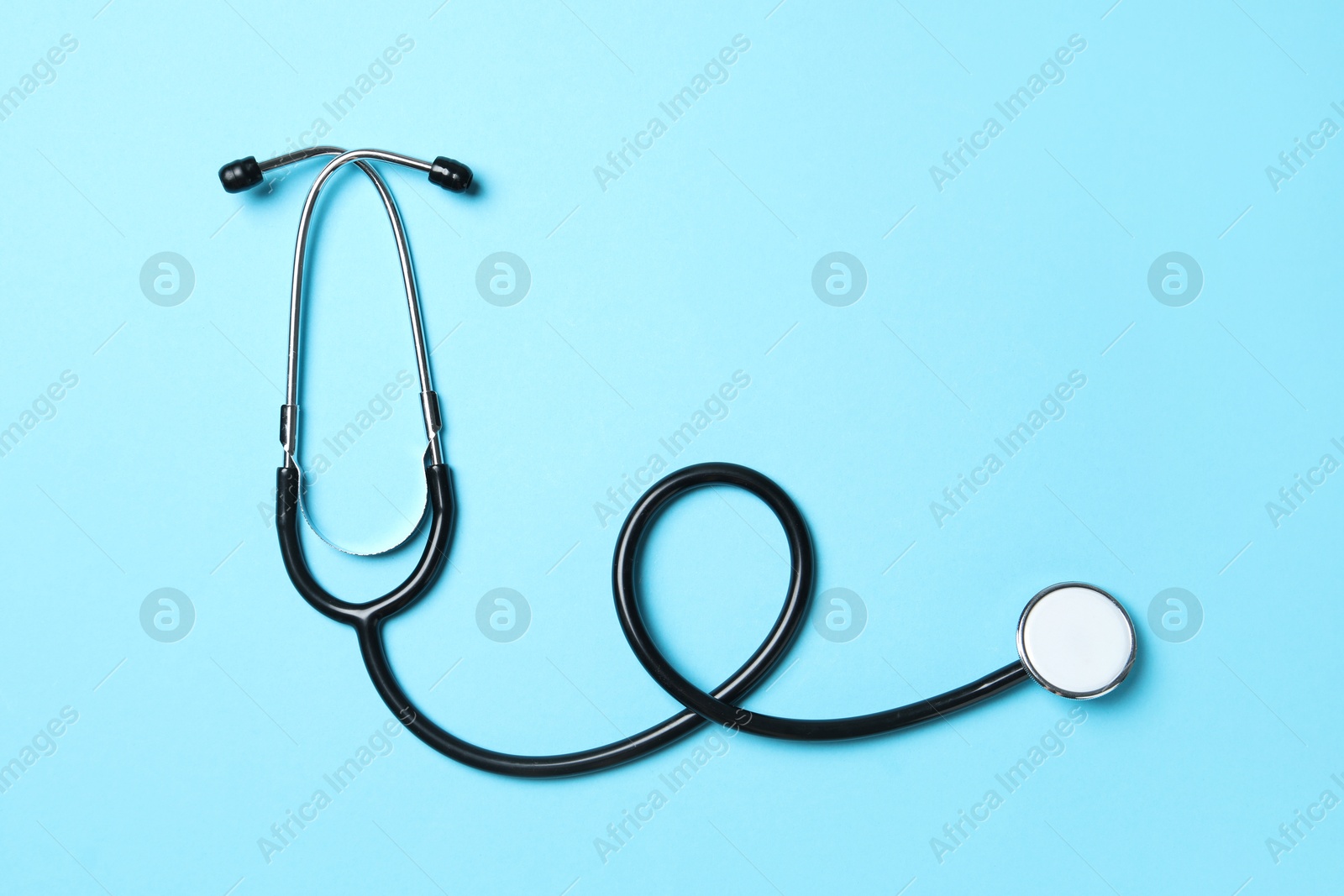 Photo of Stethoscope on light blue background, top view. Medical treatment