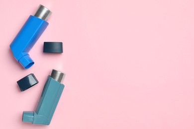 Photo of Asthma inhalers on pink background, top view. Space for text