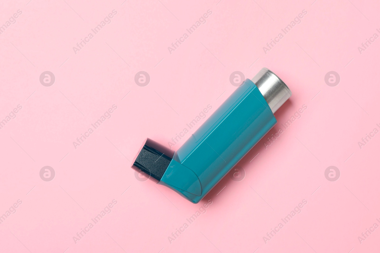 Photo of Asthma inhaler on pink background, top view