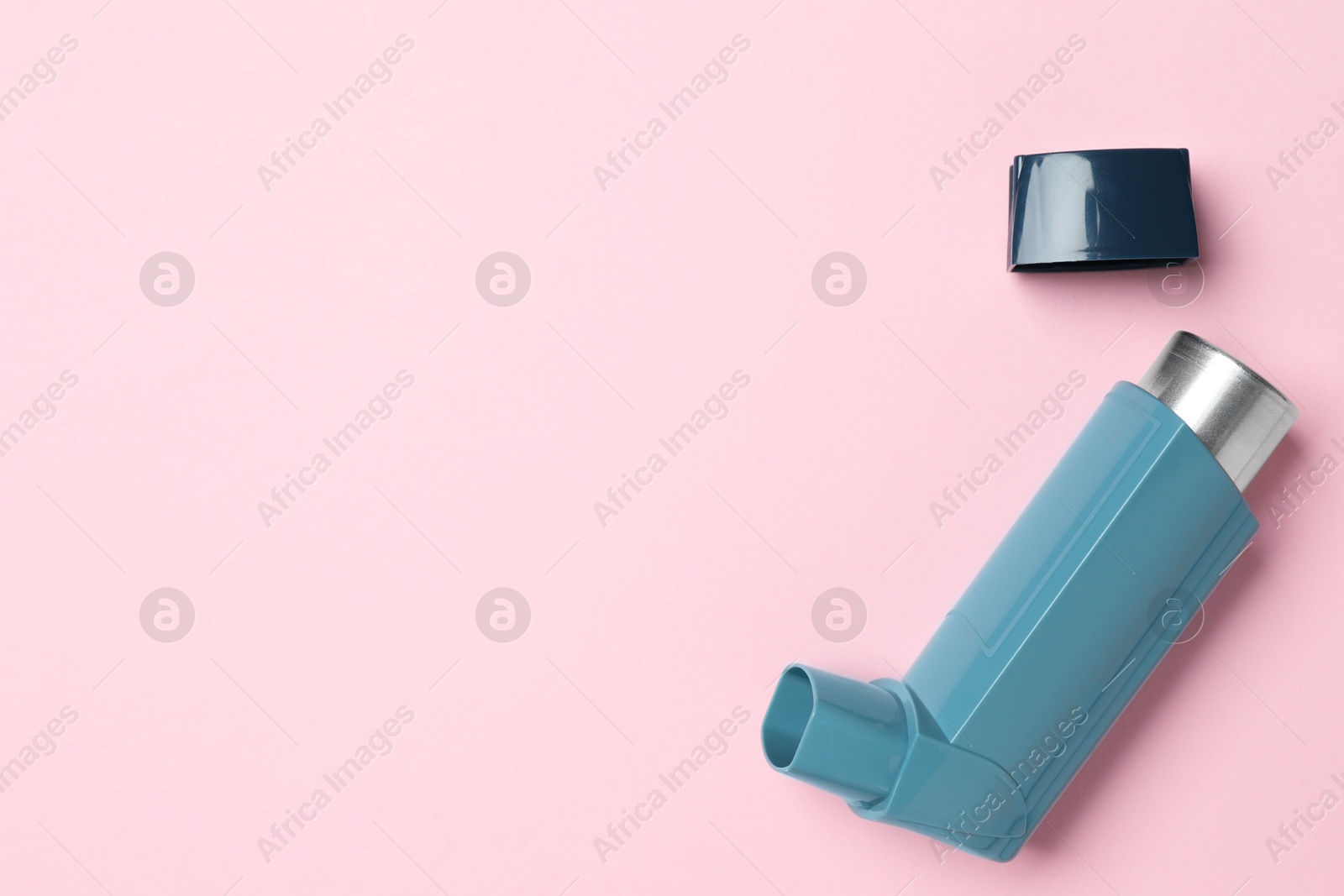 Photo of Asthma inhaler on pink background, top view. Space for text