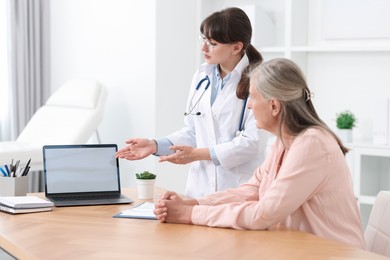 Photo of Lung disease. Doctor showing something on laptop to her patient in clinic