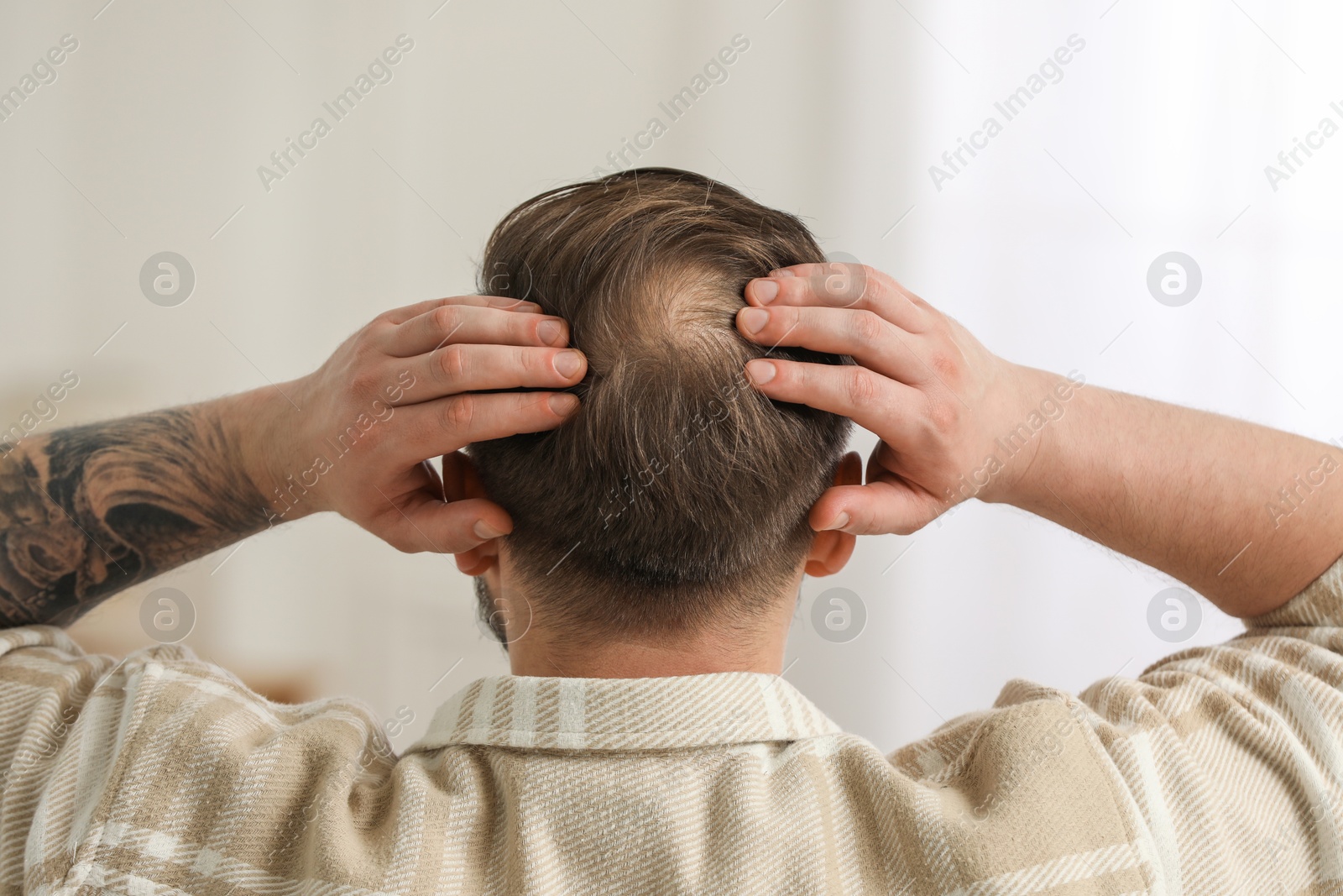 Photo of Baldness concept. Man with bald spot indoors, back view