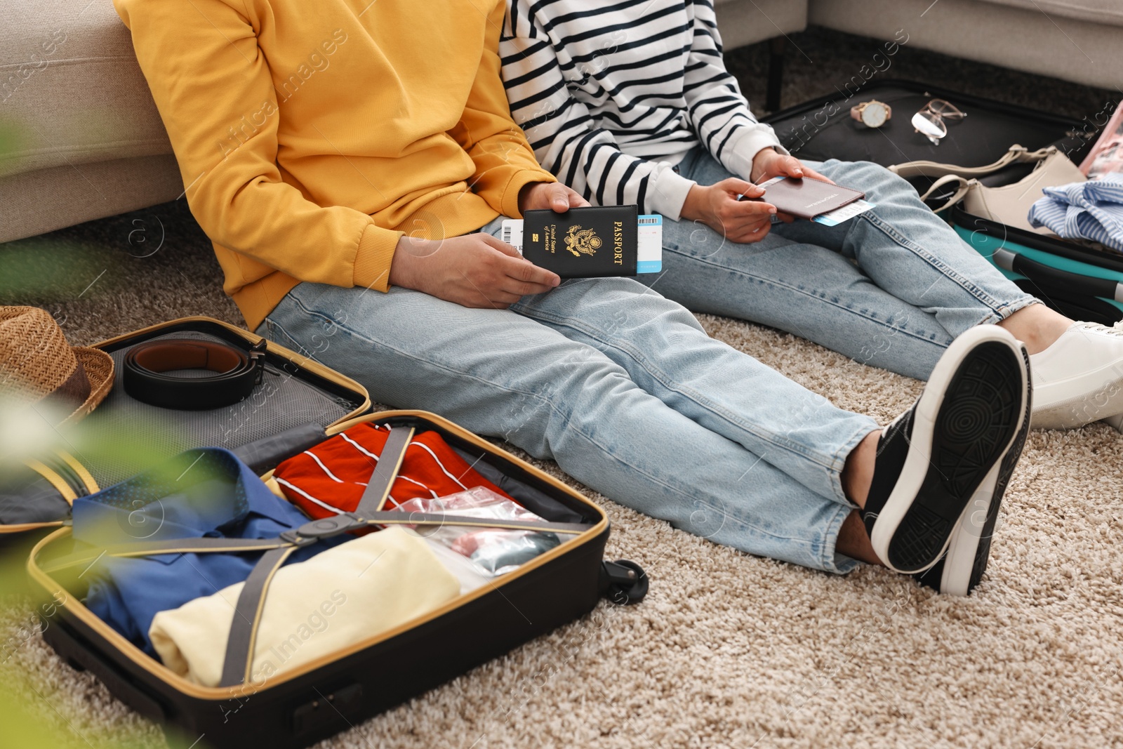 Photo of Couple with passports and tickets near suitcases on floor indoors, closeup