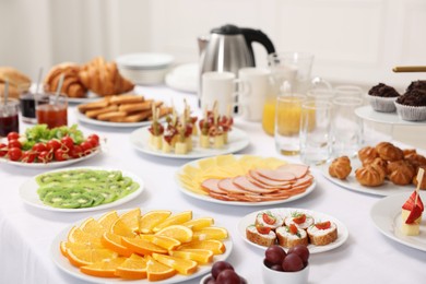 Different meals served on white table indoors. Buffet menu